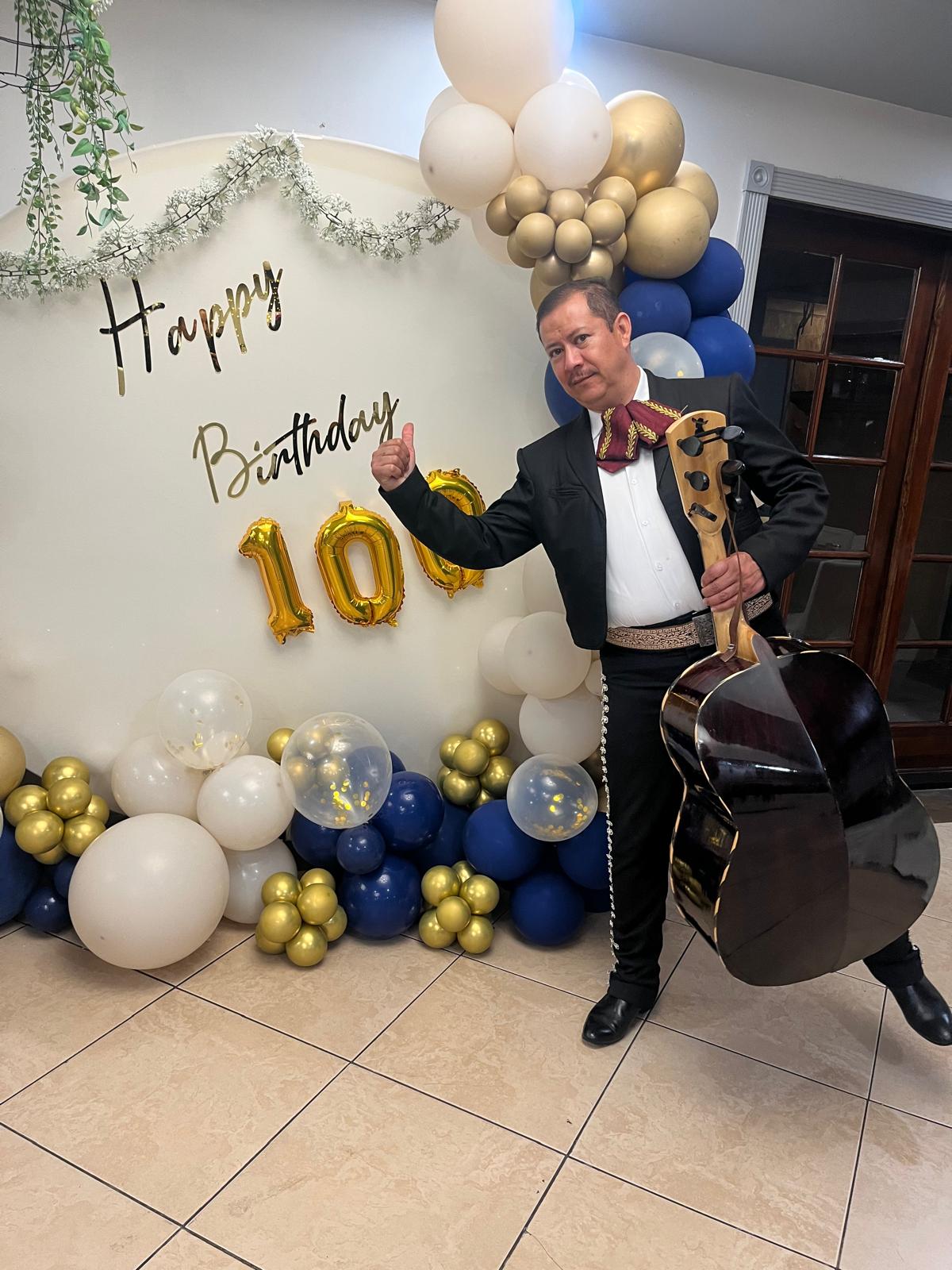 Musician with a guitarrón at a 100th birthday party
