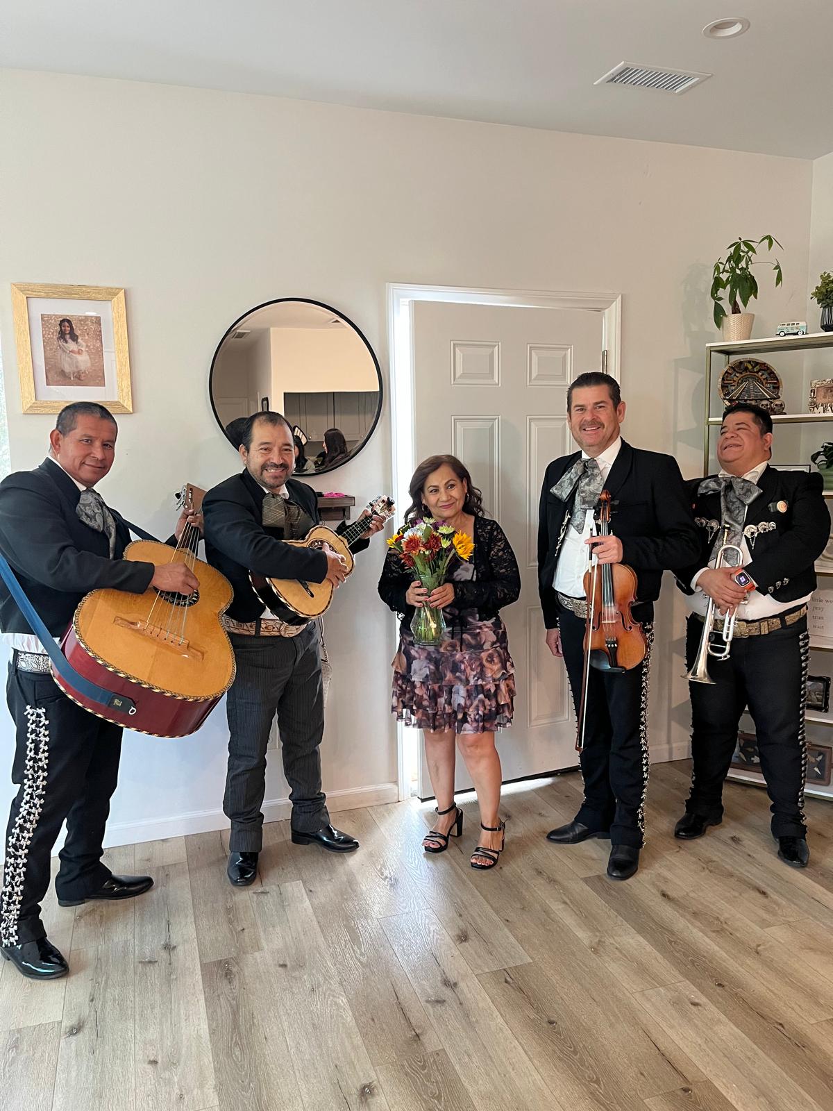 Mariachi musicians with a woman holding flowers