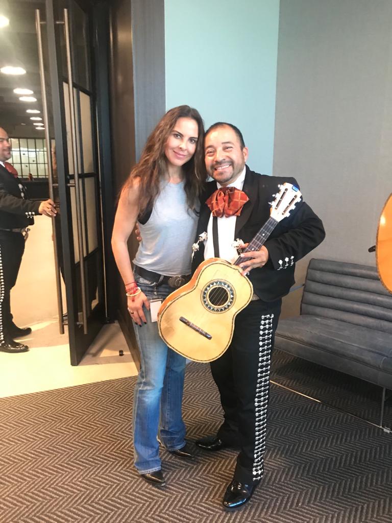 Mariachi guitarist with a guest indoors