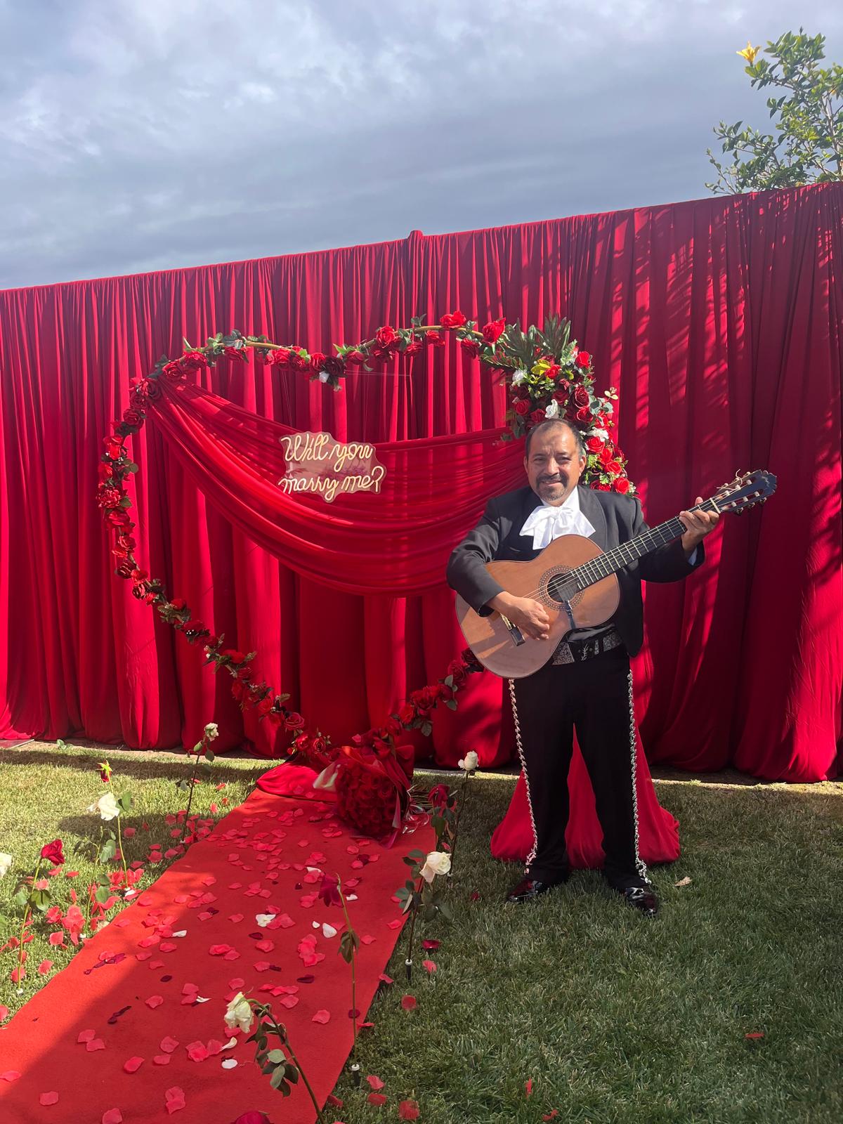 Guitarist in front of red marriage proposal decorations