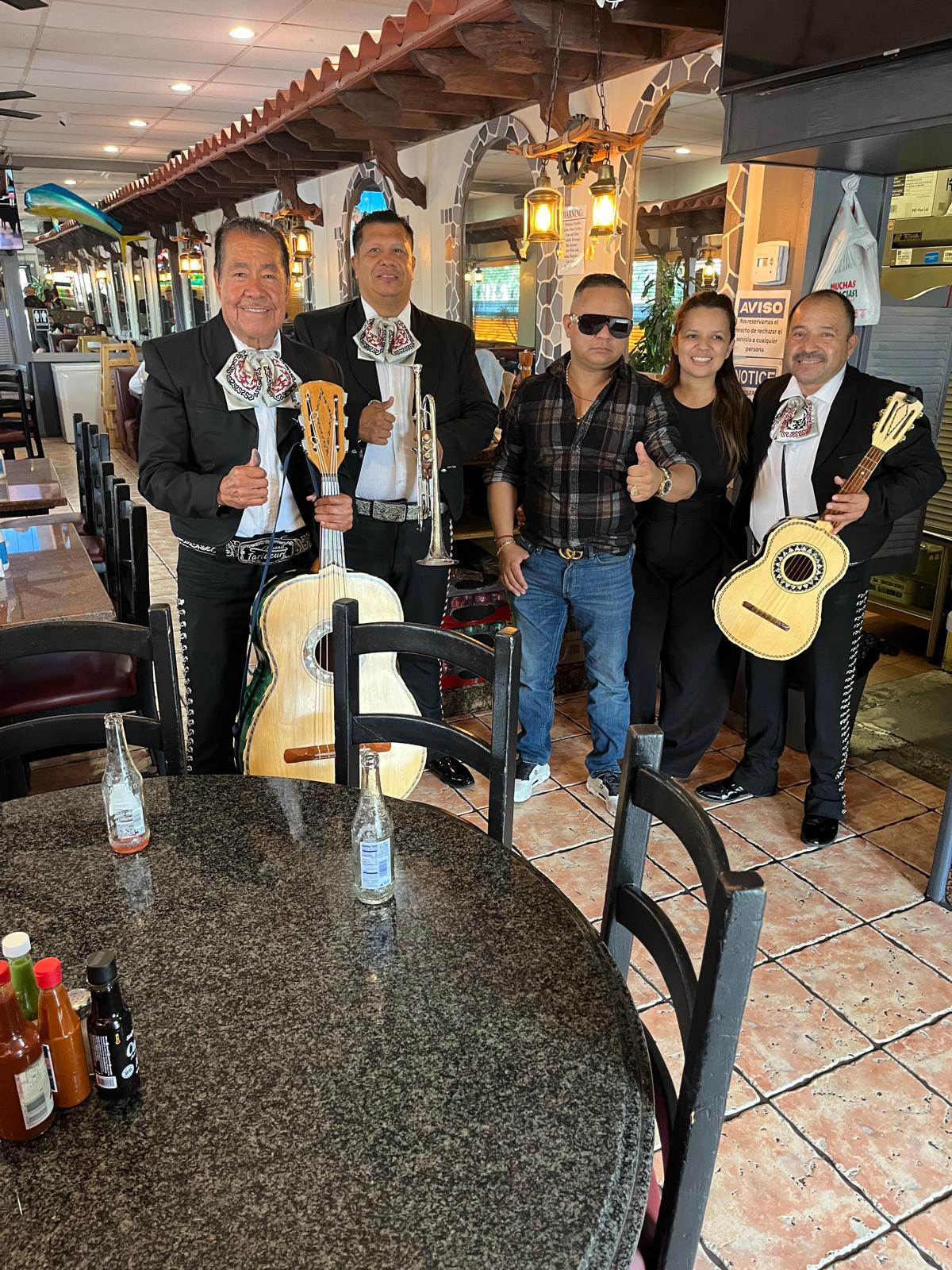 The mariachi band with a couple during a restaurant serenade