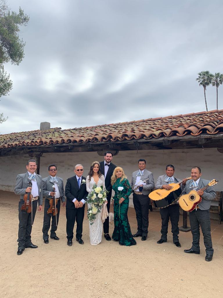 The mariachi band with a wedding party in a courtyard