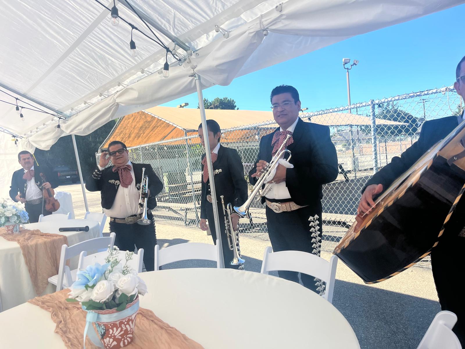 Mariachi musicians performing under a wedding tent